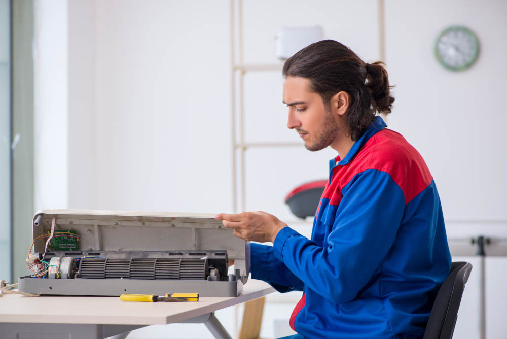 technician repairing air conditioner