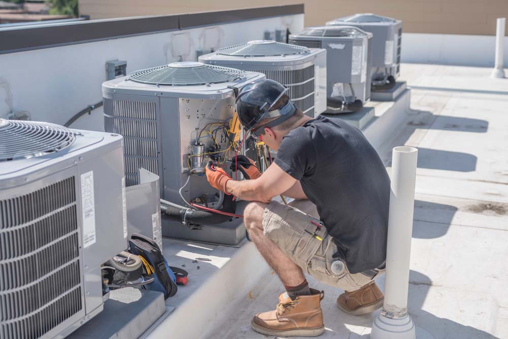 Technician tinkering with an HVAC system Byron Center, MI