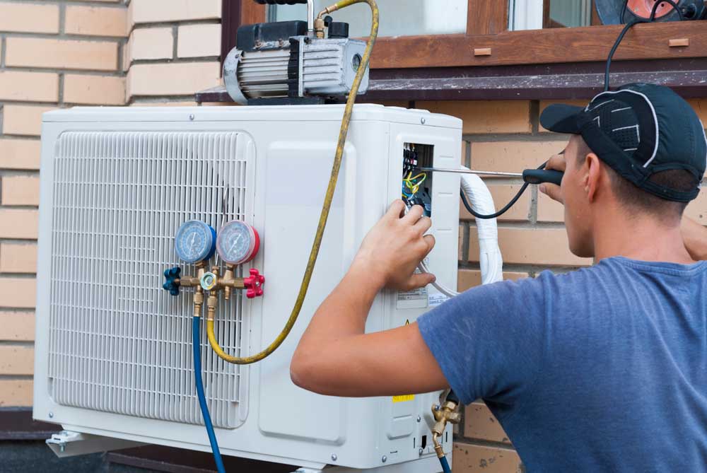 technician inspecting an HVAC system Jenison, MI