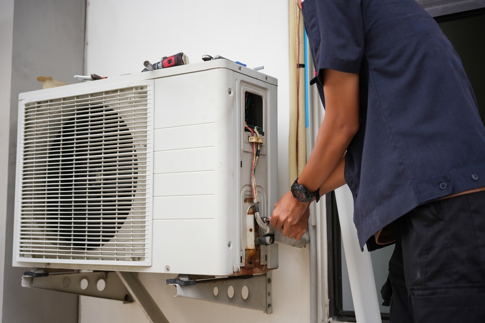technician tinkering with an HVAC system