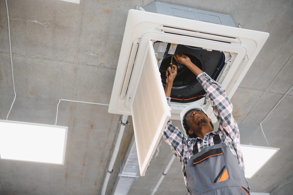technician servicing ceiling cassette ac