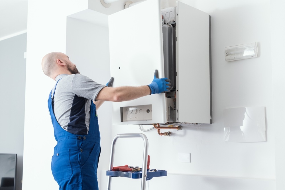 technician servicing wall mounted boiler unit
